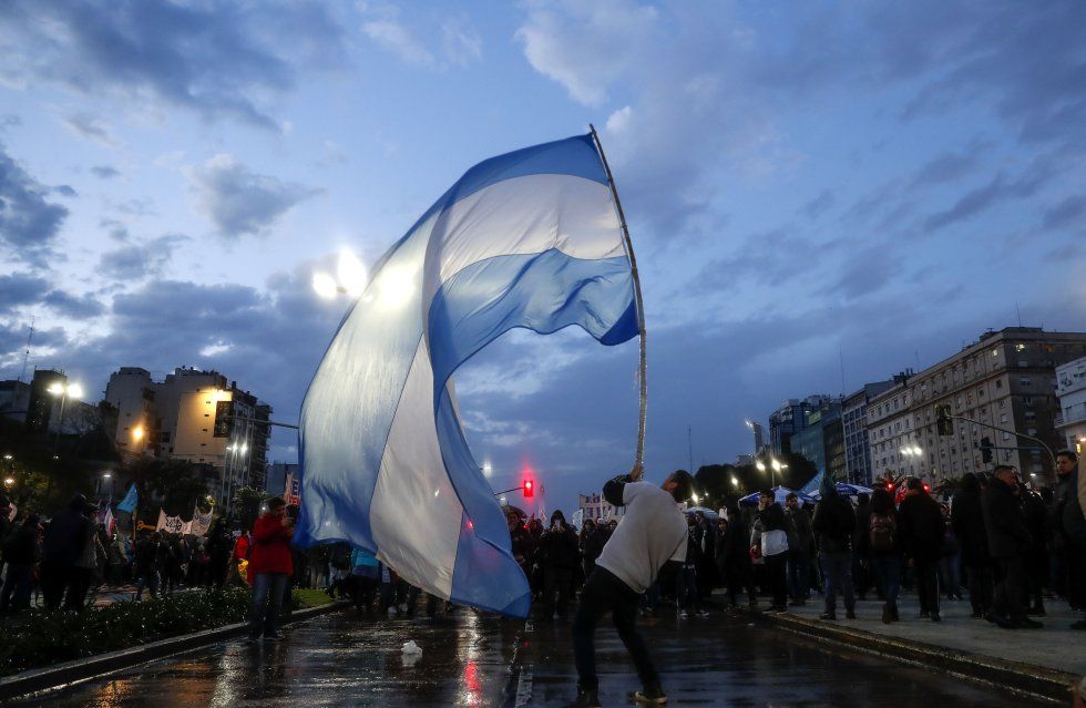 Manifestante levantando una gran bandera argentina en Avenida 9 de julio