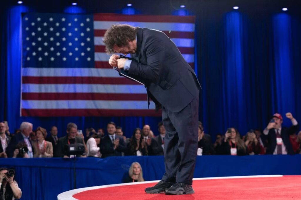 Milei se rebaja frente a la bandera de estados unidos